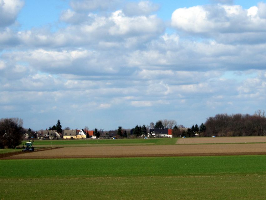 Im Vordergrund Felder und im Hintergrund eine Siedlung